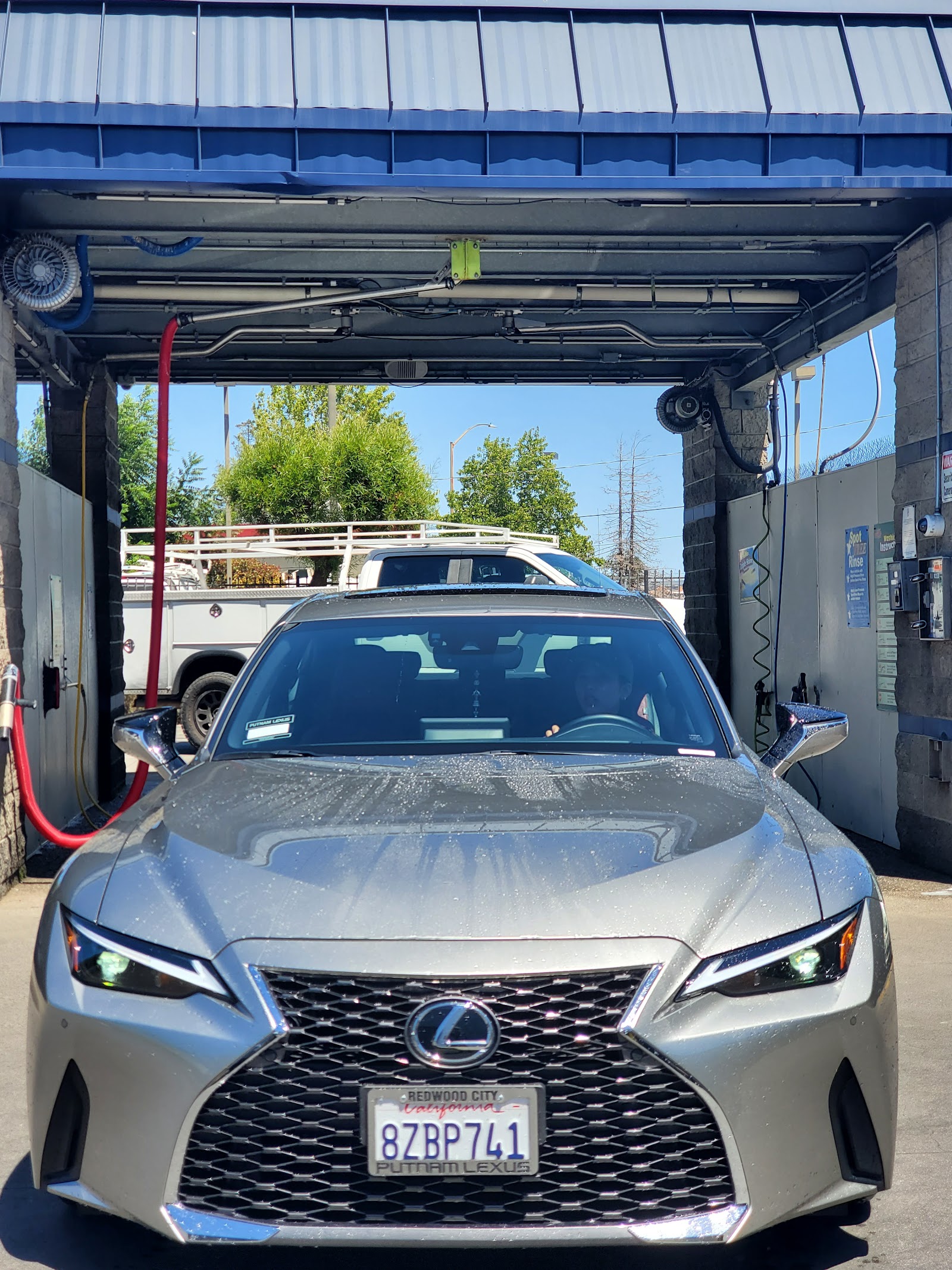 A silver Lexus IS, freshly washed, parked in a Clear Water bay with a Redwood City license plate frame.